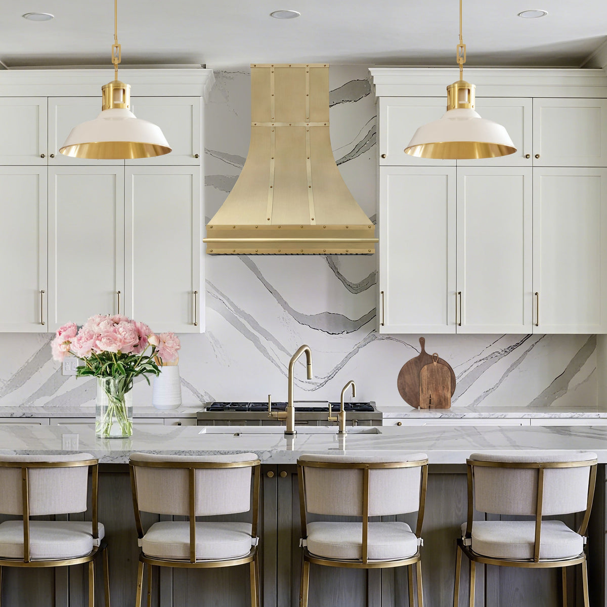 Modern kitchen with white cabinets, marble countertop, and gold fixtures.