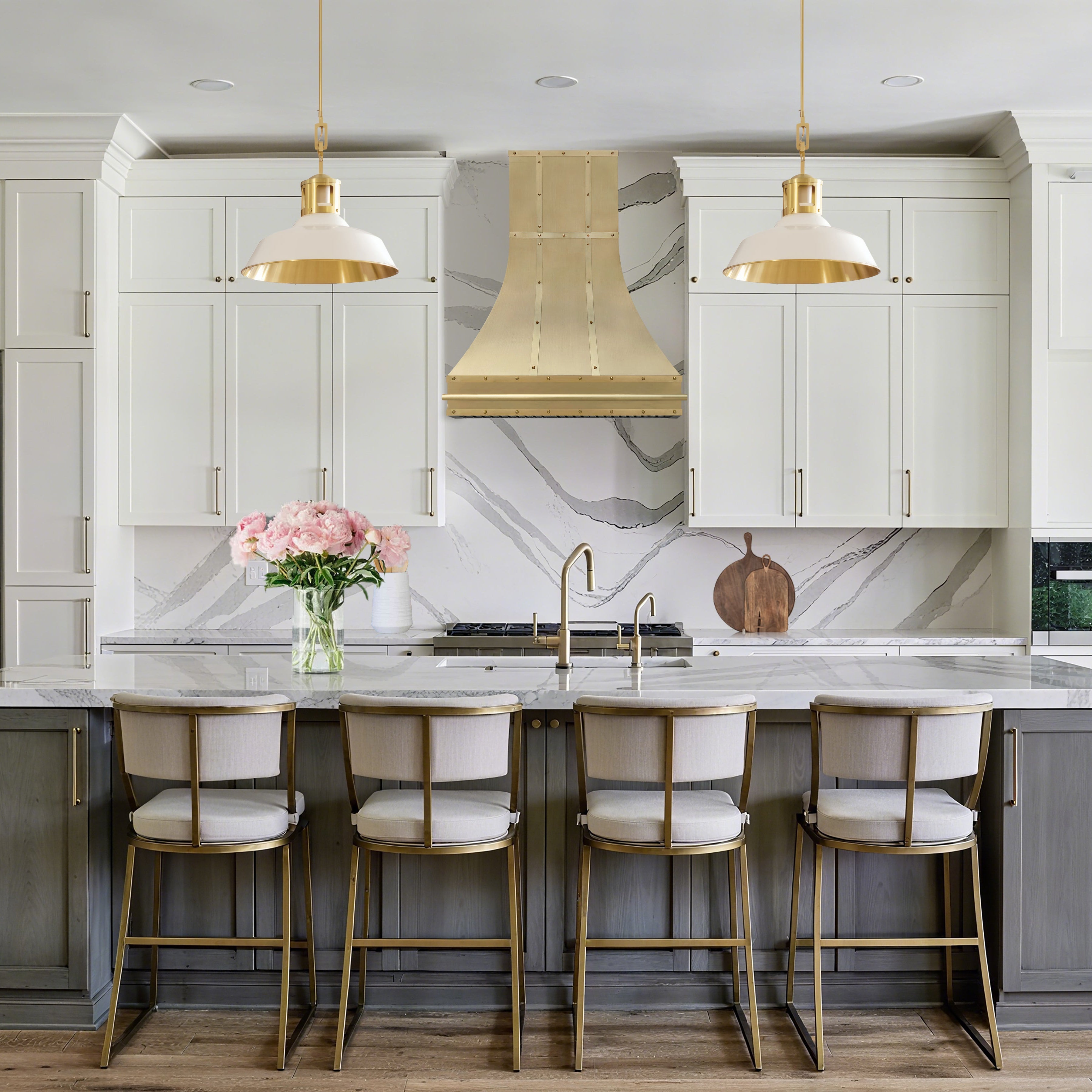 Modern kitchen with white cabinets, marble countertop, and gold fixtures.