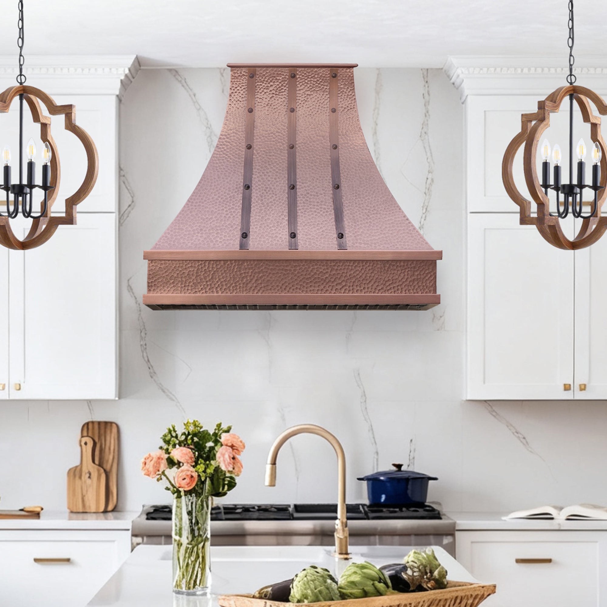 Modern kitchen with copper range hood, marble countertop, and decorative elements.