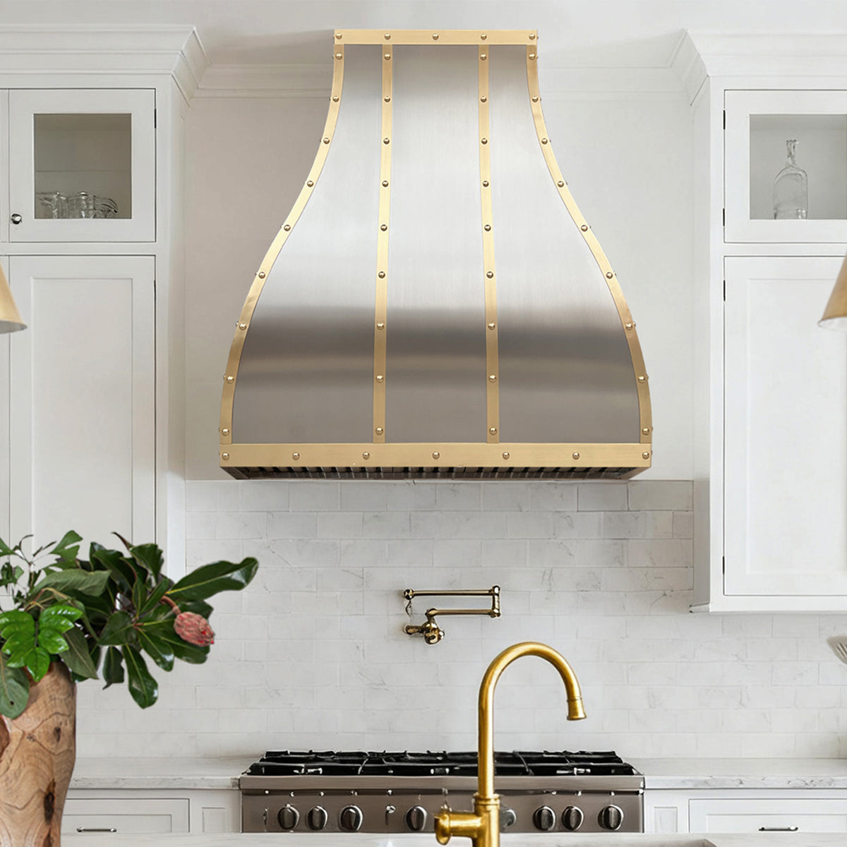 modern kitchen with stainless steel range hood with brass straps and round rivets
