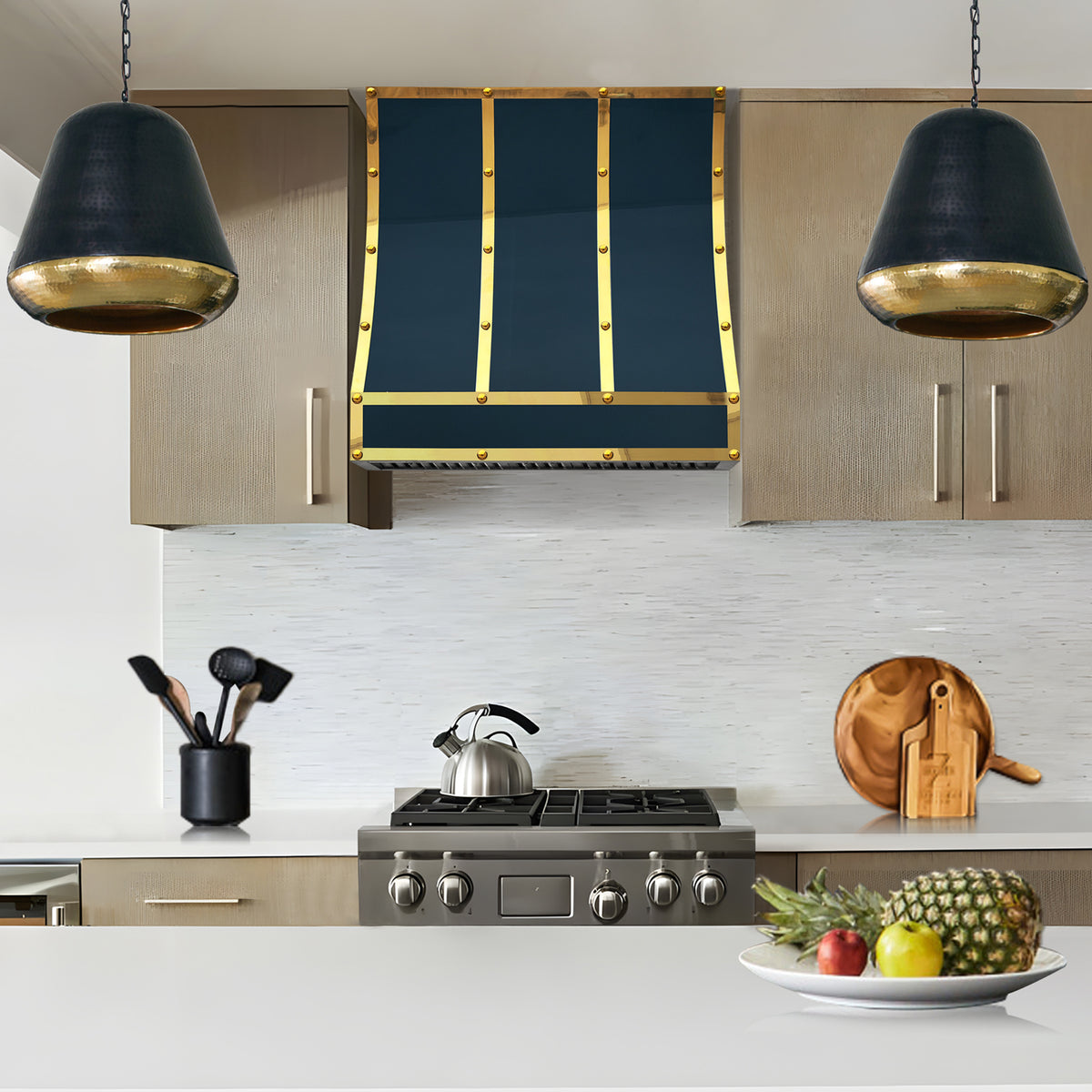 blue stainless steel range hood with brass straps in a modern kitchen