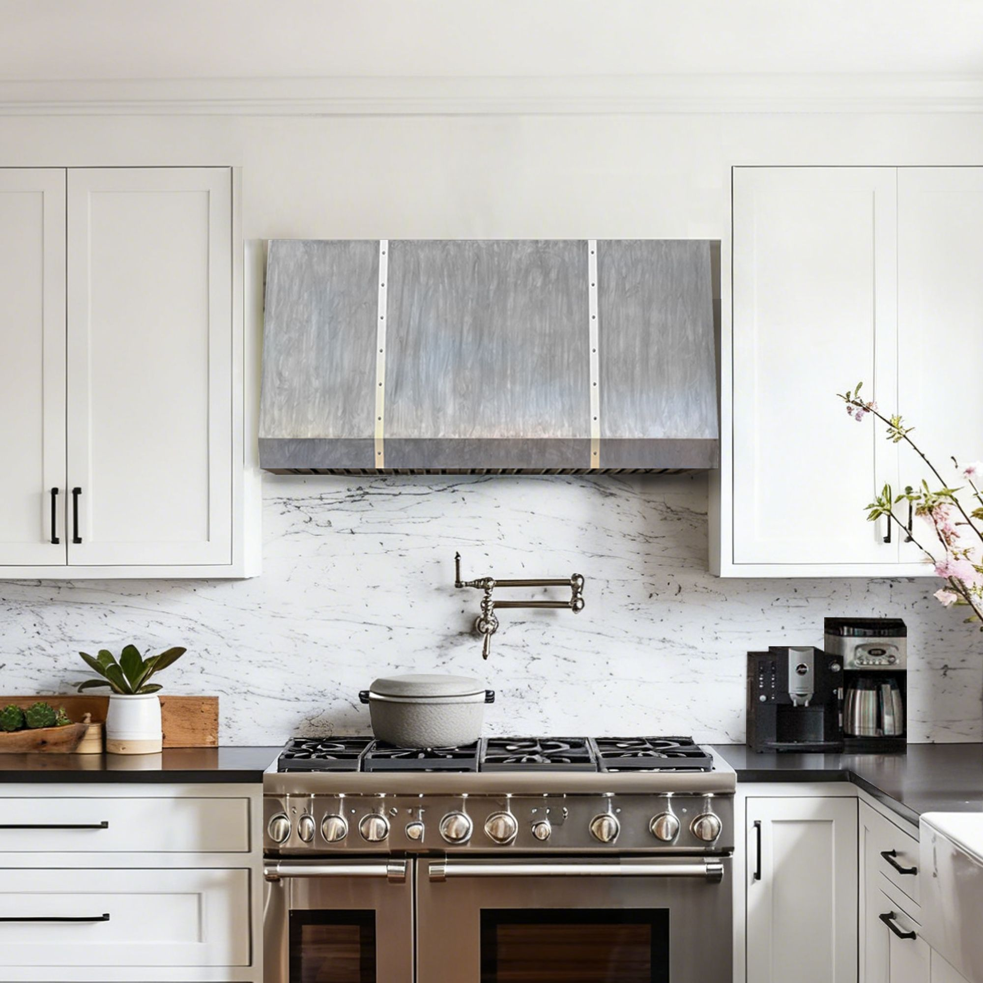 a modern kitchen scene featuring a large custom zinc range hood with vertical brushed metal panels and brass-toned accents, mounted above a gas stove