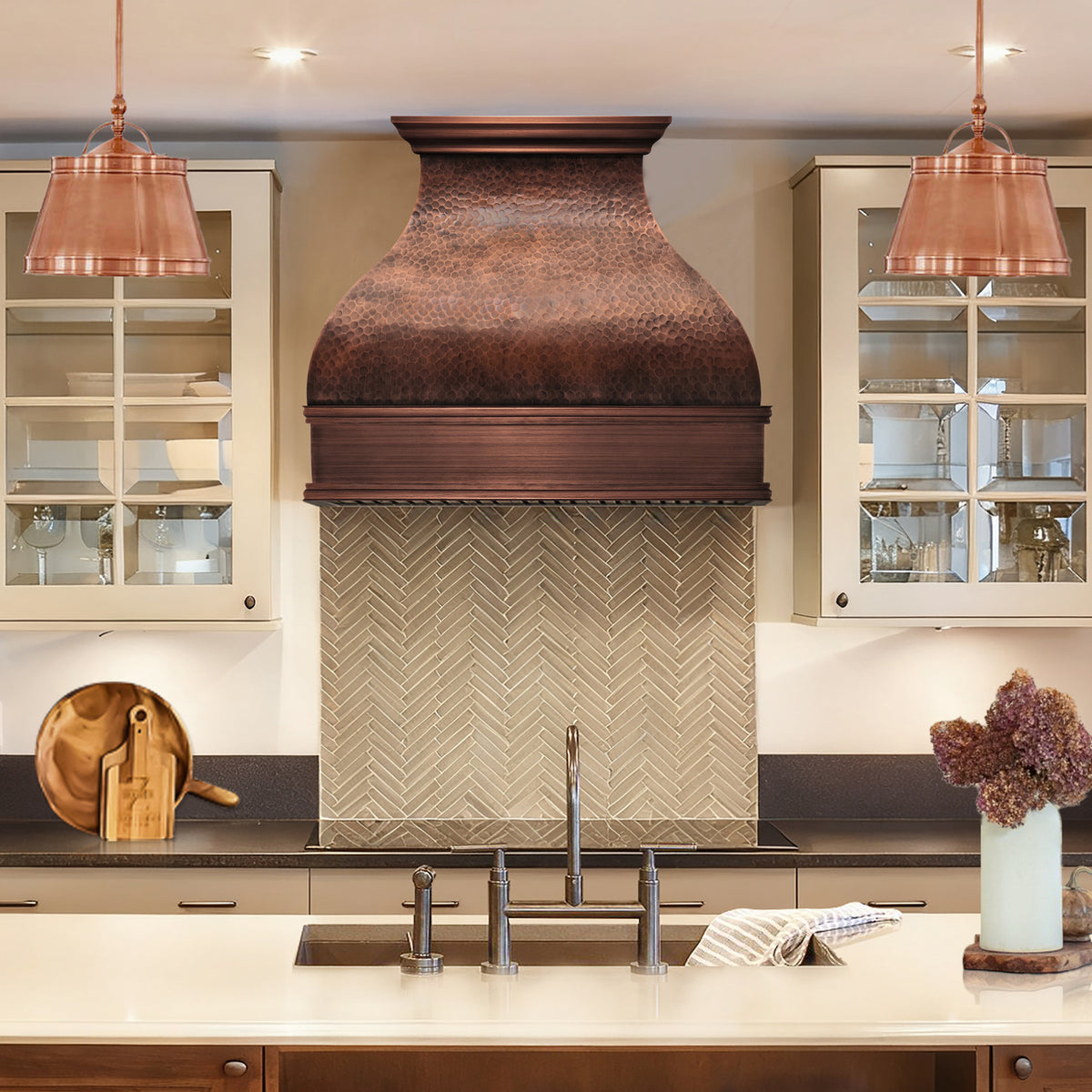 bell-shaped hammered copper range hood with a dark finish and stepped crown and apron
